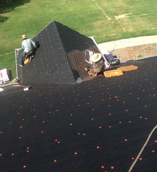 DRI Construction roofers installing a new roof on a home